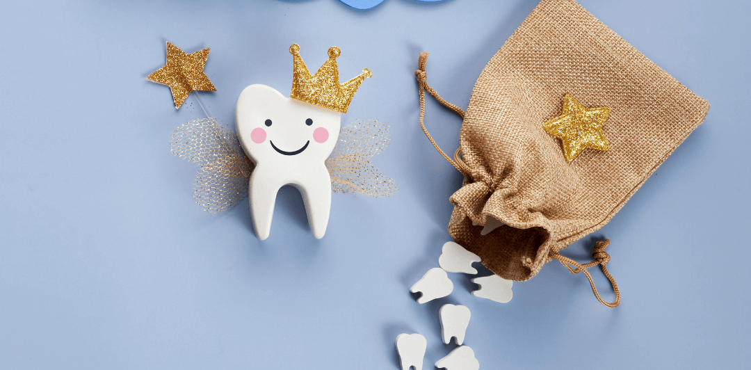 A wooden cut-out tooth dressed as the tooth fairy next to a brown hessian bag with smaller wooden teeth scattered out of it.