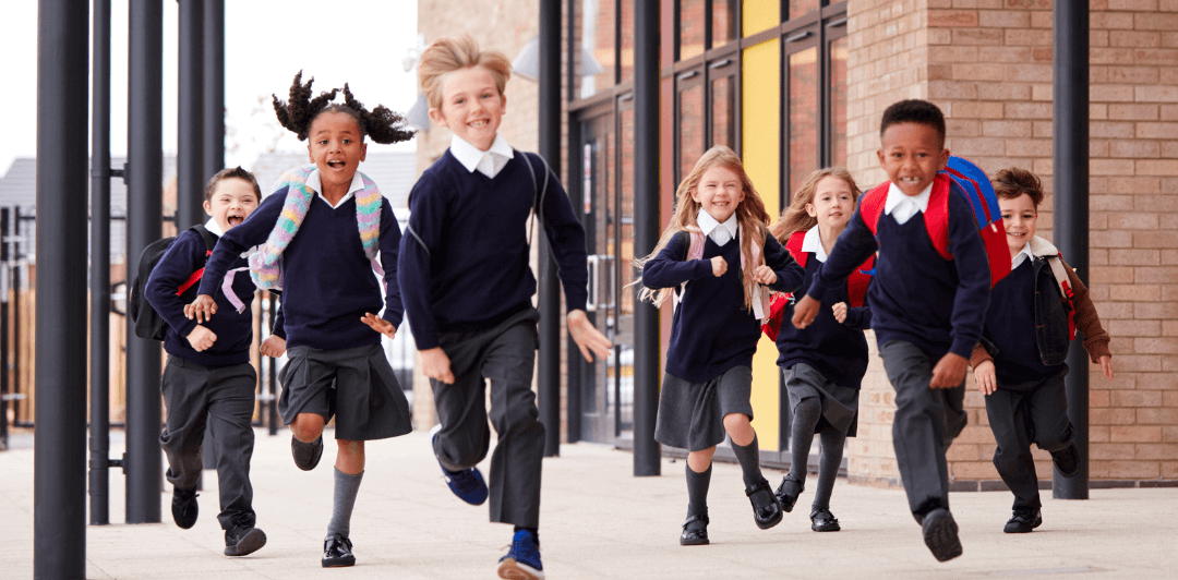 A group of primary school children running towards the camera.